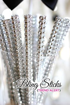 there are many silver and gold beads in the glass vase with black bow tie on it