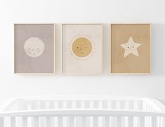 three framed pictures hang on the wall above a crib