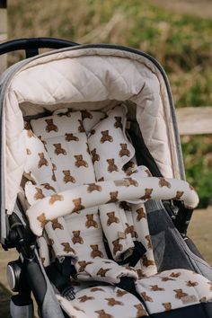 a baby stroller with brown teddy bears on it's seat and back cover