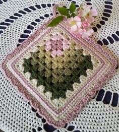 a crocheted doily with pink flowers on it