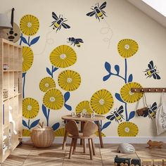 a child's room with yellow and blue flowers on the wall, wooden toys in front of it