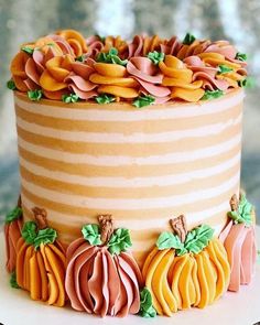 a cake decorated with pumpkins and leaves on a plate