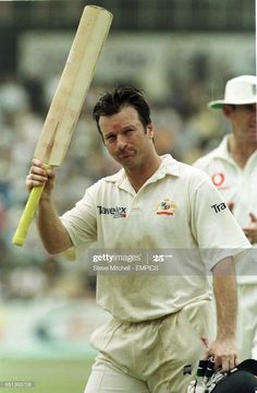 a man holding a bat and helmet in his hand