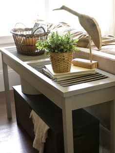 a living room with a couch, coffee table and potted plant on top of it