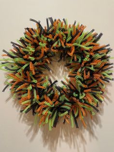 an orange and green wreath hanging on the wall