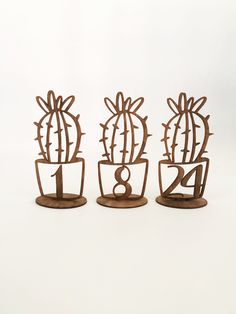 three metal cactus sculptures sitting next to each other