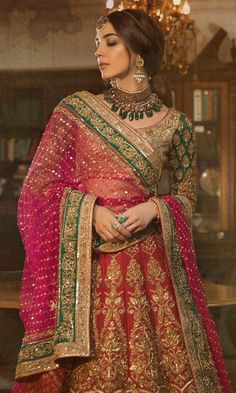 a woman in a red and gold lehenga, with jewelry on her neck