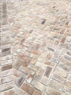 an umbrella is sitting on the side of a brick road with cobblestone pavement