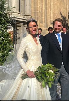 a man and woman standing next to each other in front of a building with their faces cut out