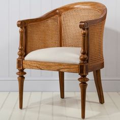 a wooden chair sitting on top of a hard wood floor next to a white wall