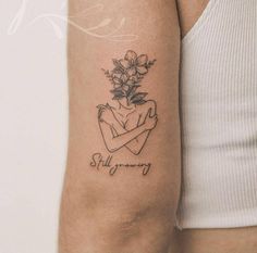 a woman's arm with a tattoo on it that says stay strong and flowers