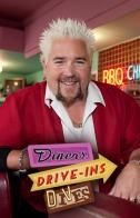 a man with white hair sitting in a chair next to a drive - in sign