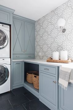 a washer and dryer in a laundry room next to cabinets with doors open