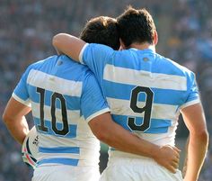 two men in blue and white uniforms hugging each other