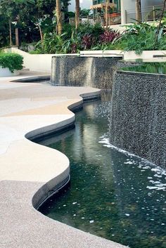 the water is running down the side of the building and there are palm trees in the background