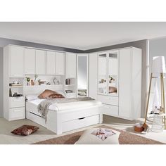 a bedroom with white furniture and lots of storage space on the wall, including a bed