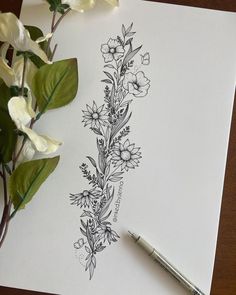 a pen and some flowers on top of a piece of paper with watercolor pencils