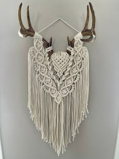 a white wall hanging with antlers on it