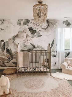 a baby's room with floral wallpaper and a crib