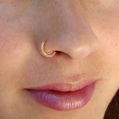 a woman's nose with a small gold nose ring on top of her nose