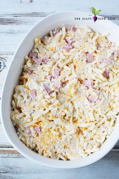 a white bowl filled with cheese and ham