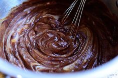 a mixing bowl filled with chocolate and whisk