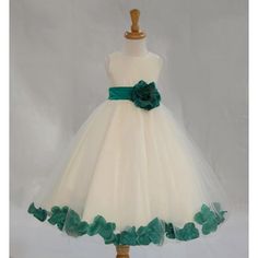 a white and green flower girl dress on a mannequin