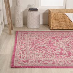 a pink area rug in the corner of a room