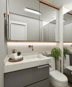 a bathroom with a toilet, sink and mirror in it's center piece is shown