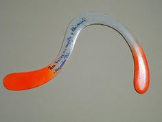 an orange and white toothbrush with writing on it