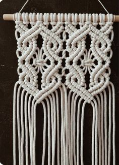 a white macrame hanging on a wall