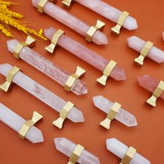 several pieces of gold and pink crystal on an orange surface