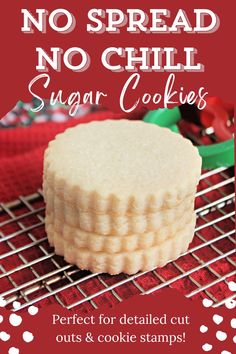 A stack of no spread sugar cookies with a scalloped edge on a cooling rack with Christmas cookie cutters in the background. Cut Out Sugar Cookies Sallys Baking, How To Make Flooded Cookies, Christmas Cookie Stamp Recipe, Cooking Hall Sugar Cookies, Stamp Cookie Dough Recipe, Easy Roll And Cut Sugar Cookies, No Rise Cookie Recipe, Perfect Sugar Cookies For Decorating, No Fail Cut Out Sugar Cookies