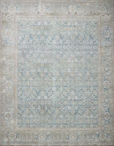 an antique rug with blue and grey colors on the ground, in front of a white background