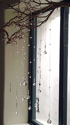 a bathroom with a tree branch hanging over the bathtub, and glass beads on the shower curtain