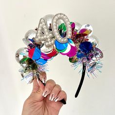 a woman's hand holding up a balloon wreath with the number 40 on it