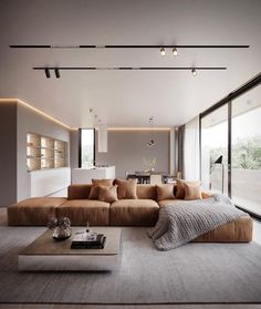 a living room with large couches and lots of windows on the side of it