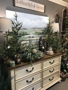 a dresser with christmas trees and other decorations on it