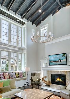 a living room filled with furniture and a fire place in front of a large window