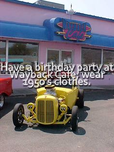 an old yellow car is parked in front of a birthday party at a clothing store