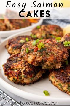 crab cakes on a white plate with lemon wedges and green onions in the background