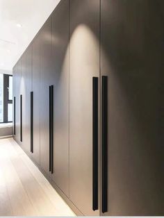 an empty hallway with black doors and white walls