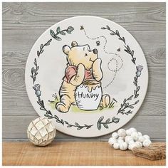 a plate with a winnie the pooh on it and some marshmallows next to it