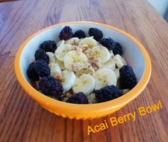 a bowl filled with bananas and blackberries on top of a wooden table