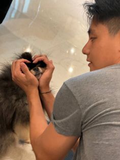 a man petting a small dog on top of a white floor