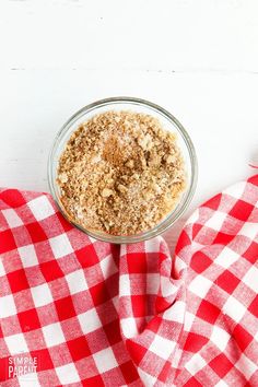 a bowl filled with oatmeal sitting on top of a red and white checkered cloth