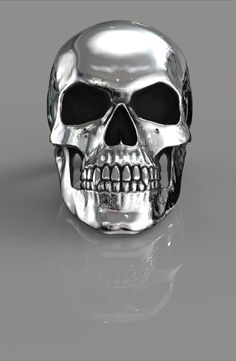 a silver skull with black eyes on a gray background