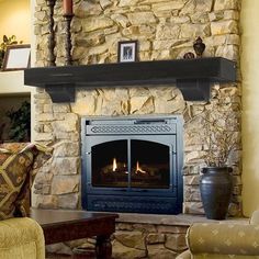 a living room with a fire place and couches in front of a stone fireplace