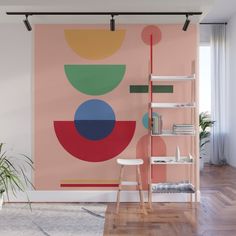 an abstract painting on a pink wall in a living room with wooden floors and shelves