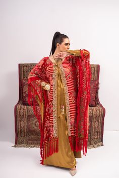 Discover luxury and elegance with our Red and Yellow Coat Shalwar Kameez. Made from plush materials, this front open poncho boasts intricate kundan work lace and resham tassels on each corner. The inner turmeric colored georgette silk shirt and pants add a touch of sophistication. Feel confident and stylish in this timeless piece. 3-Piece Suit Festive Kurta With Tassels, Festive Kaftan With Dupatta For Eid, Designer Gold Kaftan With Dabka Work, Diwali Gold Kaftan With Zari Work, Festive Kurta With Tassels And Traditional Drape, Festive Bollywood Kurta With Tassels, Red Kaftan With Dupatta For Festivals, Festive Red Kaftan With Dupatta, Gold Kaftan With Resham Embroidery For Diwali